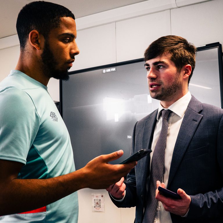 A Kyzen Sports employee having a discussion with a footballer
