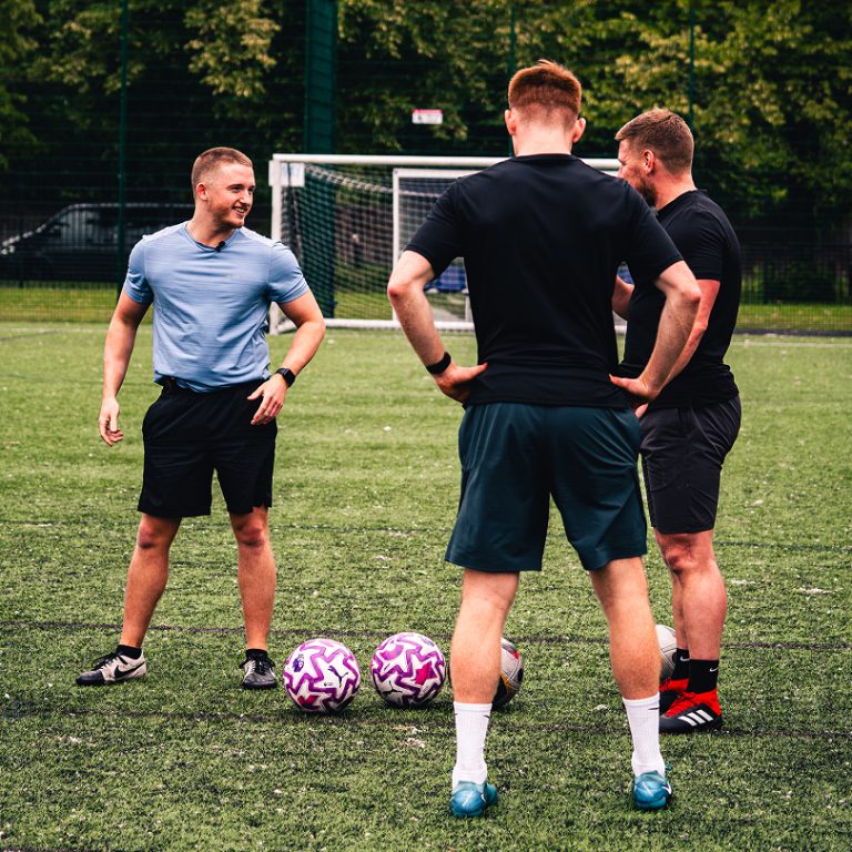 3 men talking during a football training session