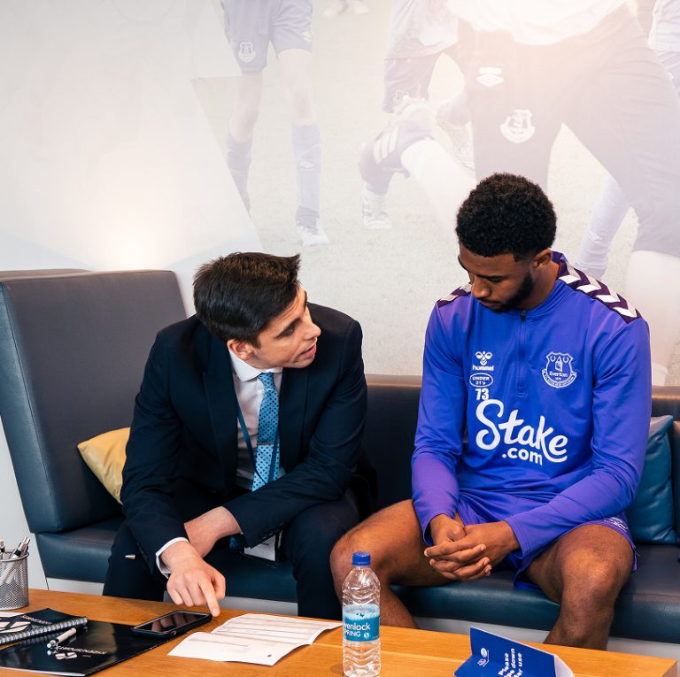 Kyzen employee in a suit filling out a form with a footballer