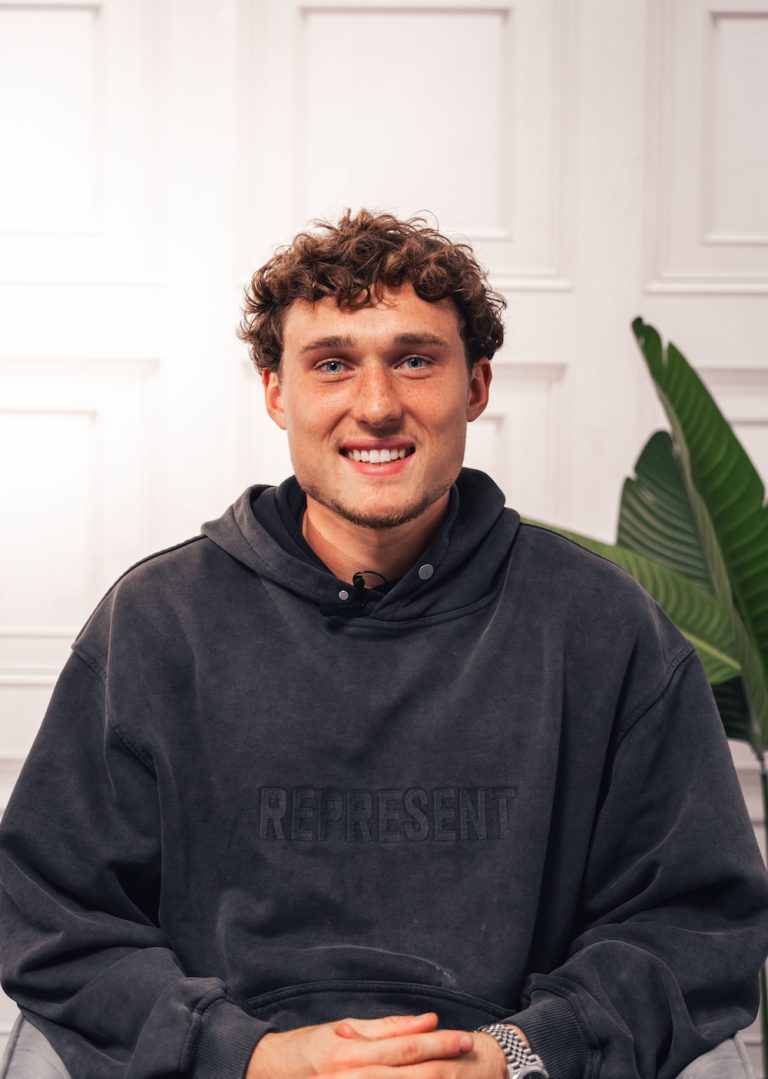 Former Bury Midfielder Callum Styles sat down smiling wearing a grey hoodie