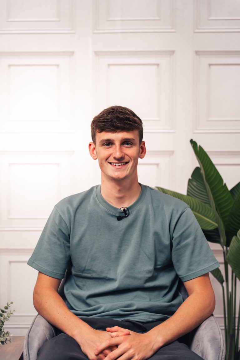 Former Liverpool Midfielder Tyler Morton smiling in a muted green t-shirt